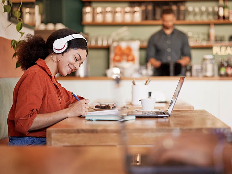 woman working laptop coffee headphones