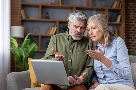 couple confused looking at laptop