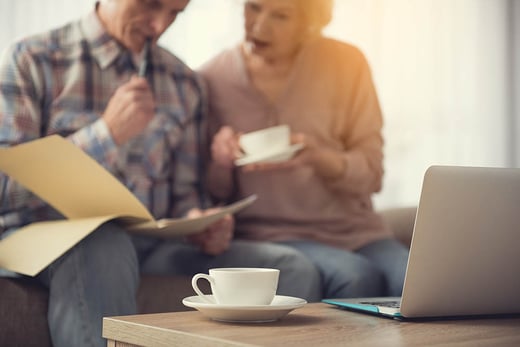 couple reviewing document with laptop in the foreground 1000