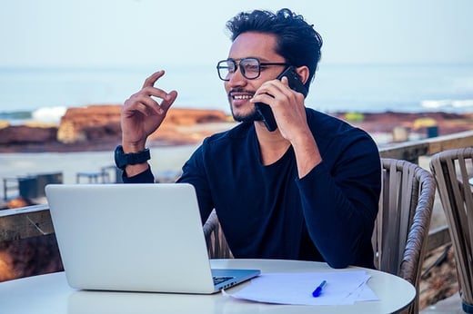 man on phone abroad with laptop
