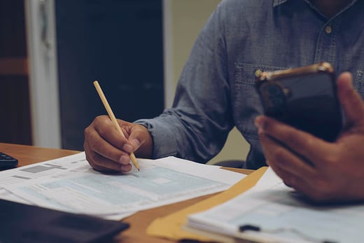 man with pencil completing tax form