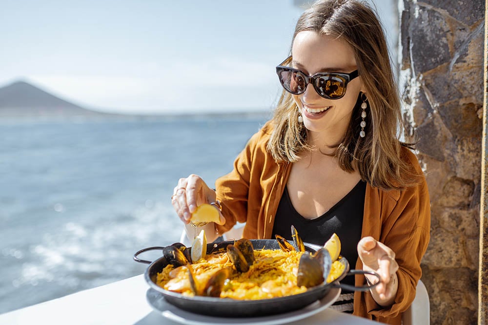 woman eating paella outside
