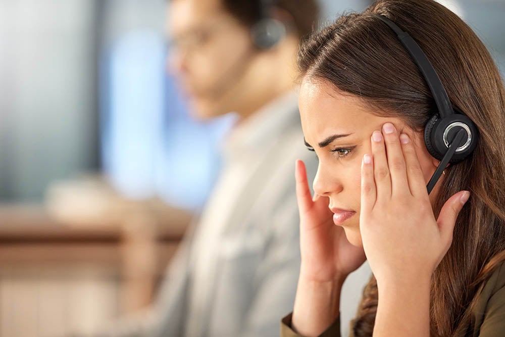 woman with headset looking concerned