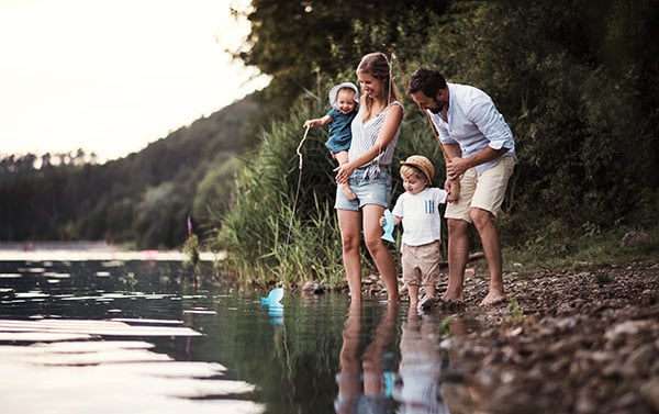 young family beside a river